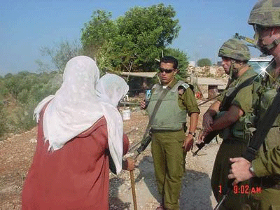 Two Palestinian women approach the Israeli soldiers.