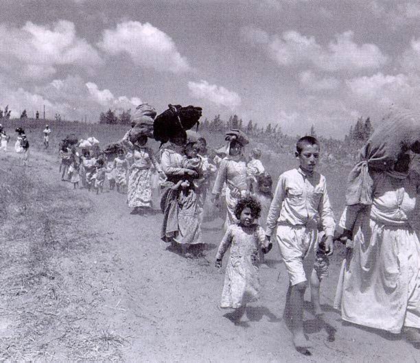 Photo of Palestinian woman and children fleeing. In 1948, 804,767 Palestinian men, women, and children were forced to flee their homes. This photograph shows a train of Palestinians who were soon to become lifelong refugees.
