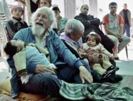 Father Peter Dougherty and Sister Mary Ellen Gundeck sit on the rooftop of the house of Mohammad Baroud, holding Palestinian infants in their arms.